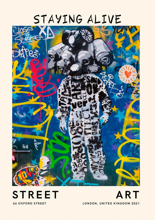 Colorful urban mural of a figure in black lettered suit, surrounded by vibrant graffiti. Text: Staying Alive.