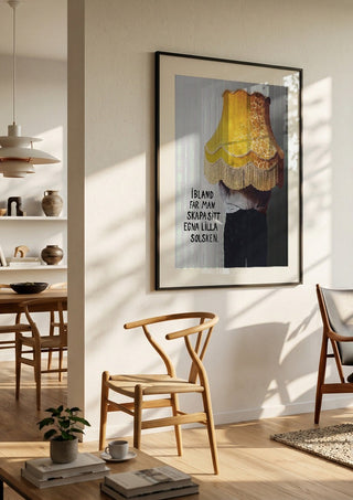 Solsken by Grafik bageri in a black frame in a bright dining room with wooden chairs