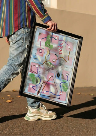 Dreaming The White Dots by Art Guveau carried in a black frame along a sunny street