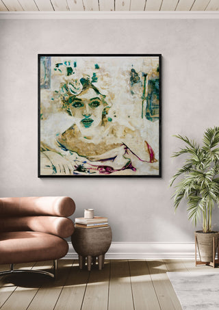 Norma by Mushk in a black frame above a tan leather chair beside a potted plant