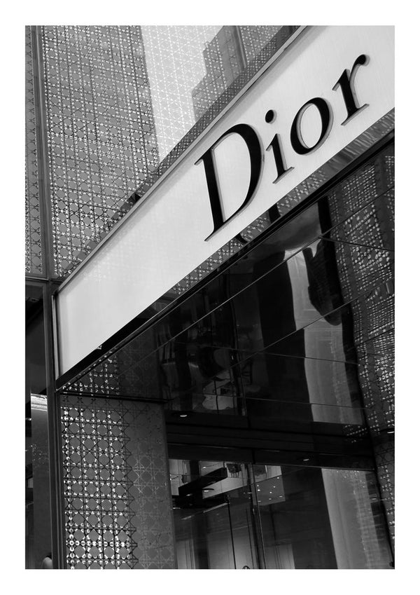 Exterior of a Dior boutique with the brand logo displayed above glass doors and patterned wall panels.