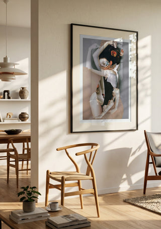 Pebbles by Rocio Montoya in a black frame in a bright dining room with wooden chairs