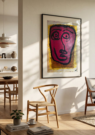 Livrädd by RR in a black frame in a bright dining room with wooden chairs