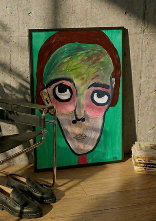 Hjärnspöken by RR in a black frame leaning against a concrete wall by a steel chair