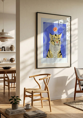 Grrrapefruit by Jakob Falkenberg in a black frame in a bright dining room with wooden chairs