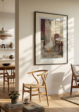 The Duck Wore Pearls by Matthews Gallerie in a black frame in a bright dining room with wooden chairs