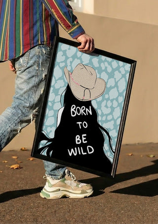 Born to be wild by Lisen Vennesland carried in a black frame along a sunny street