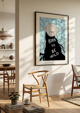 Born to be wild by Lisen Vennesland in a black frame in a bright dining room with wooden chairs