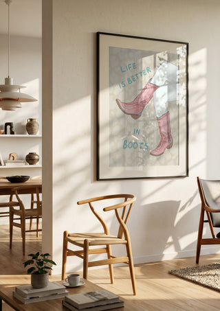 Life is better in boots by Lisen Vennesland in a black frame in a bright dining room with wooden chairs