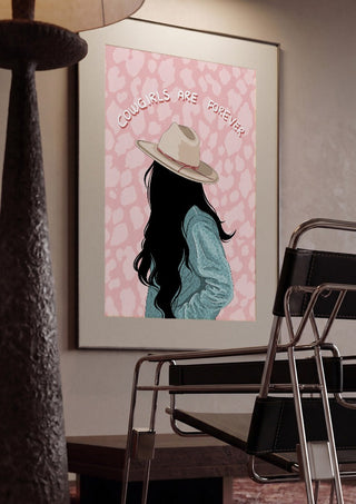 Cowgirls are forever by Lisen Vennesland framed in a dim room beside a tubular steel chair
