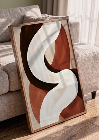 Curve in Cream by Martina Karlsson in a walnut frame leaning against a grey sofa