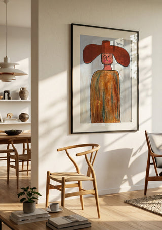 Cowboy by RR in a black frame in a bright dining room with wooden chairs