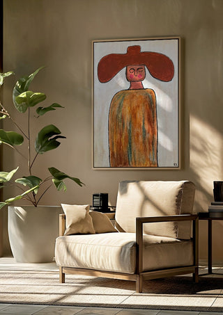 Cowboy by RR framed above a beige armchair beside a potted plant