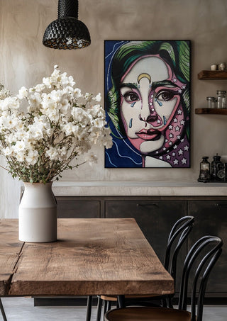 Audrey Hepburn by Okiana in a black frame above a rustic table with white flowers