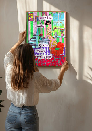 May the Coffee Kick In by Camilla Nilsson being hung on a sunlit wall