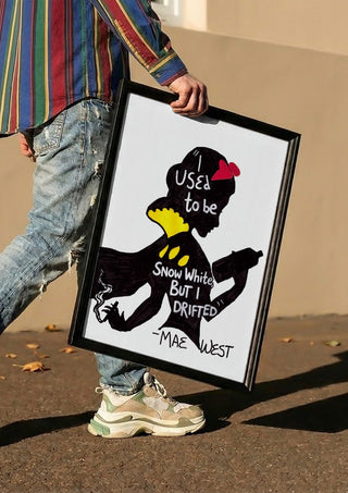 I Used to Be Snow White by Camilla Nilsson carried in a black frame along a sunny street