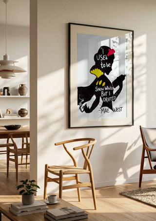 I Used to Be Snow White by Camilla Nilsson in a black frame in a bright dining room with wooden chairs