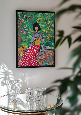 The Garden Wall by Camilla Nilsson in a black frame above a glass table with crystal glassware