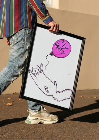 My Sanity by Camilla Nilsson carried in a black frame along a sunny street
