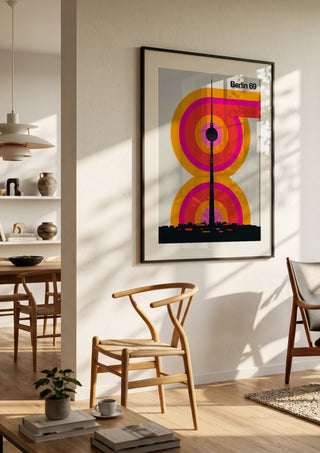 Berlin 69 by Bo Lundberg in a black frame in a bright dining room with wooden chairs