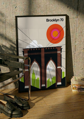 Brooklyn 70 by Bo Lundberg in a black frame leaning against a concrete wall by a steel chair