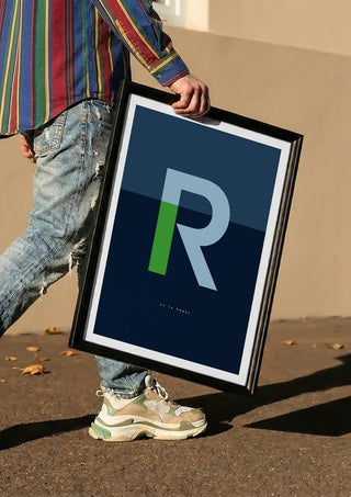 R as in Rebel – Blue by Quite Nice Prints carried in a black frame along a sunny street