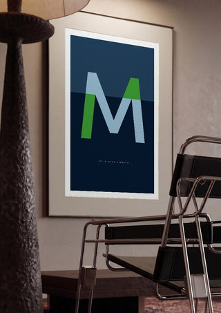 M as in Mind-blowing – Blue by Quite Nice Prints framed in a dim room beside a tubular steel chair