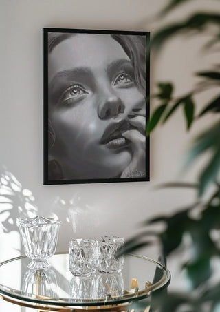 the dreamer by Sofia de Lemos in a black frame above a glass table with crystal glassware