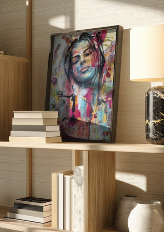 Sehnsucht by Anke Fillies in a dark frame on a wooden shelf beside books and a lamp