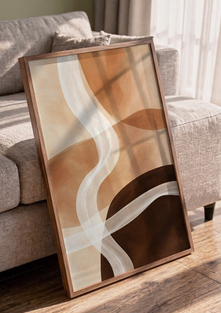 Sand and Clay by Martina Karlsson in a walnut frame leaning against a grey sofa