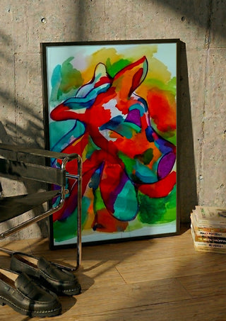 Color Pitbull 2 by Nittaart in a black frame leaning against a concrete wall by a steel chair