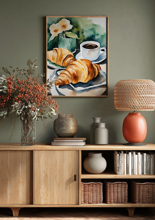 Petit dejeuner - coffee and croissants by Ohkimiko above a wooden sideboard on a sage green wall