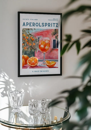Il dolce far niente - Aperol by Ohkimiko in a black frame above a glass table with crystal glassware