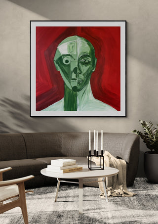 Green portrait / red field by Linor Citaku in a black frame above a curved grey sofa with candlesticks on a round table