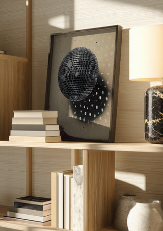 Disco Star by Carl Smith ART in a dark frame on a wooden shelf beside books and a lamp