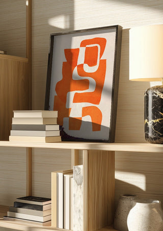 Abstract Art 55 - 7 by ThingDesign in a dark frame on a wooden shelf beside books and a lamp