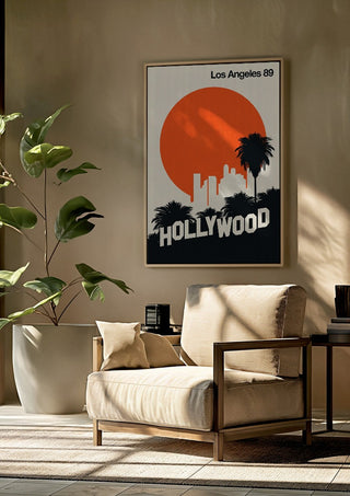 Los Angeles 89 by Bo Lundberg framed above a beige armchair beside a potted plant