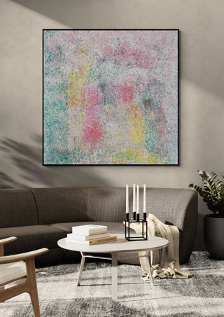 Between dream and light by Marcel Herrmann in a black frame above a curved grey sofa with candlesticks on a round table