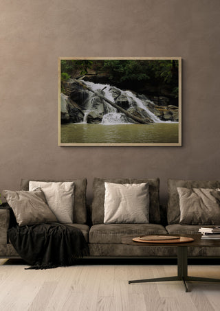 Doi Inthanon by Elefteria in a light oak frame above a grey sofa on a warm brown wall