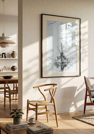 Ship and Gulls by Justyna Kopania in a black frame in a bright dining room with wooden chairs