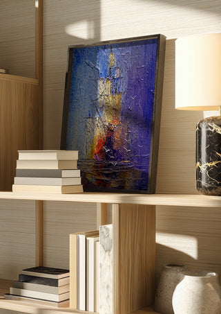 Ships in Violet and Gold by Justyna Kopania in a dark frame on a wooden shelf beside books and a lamp