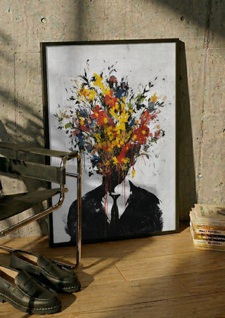 Headbloom x Banksy by Decker Studios in a black frame leaning against a concrete wall by a steel chair