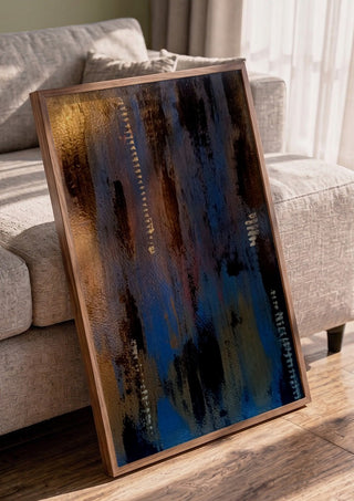 Script in Blue and Copper by Kristof ellertz in a walnut frame leaning against a grey sofa