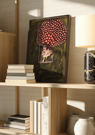 Madame Rose by Ali Kasap in a dark frame on a wooden shelf beside books and a lamp