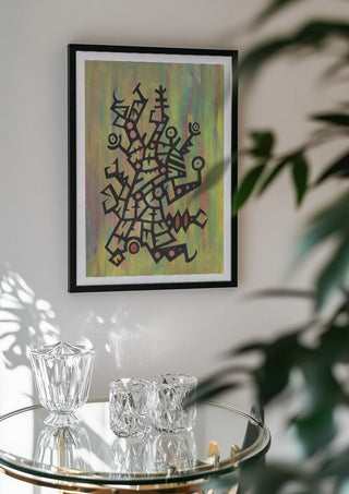 Glyphs on Green by John Larkin in a black frame above a glass table with crystal glassware