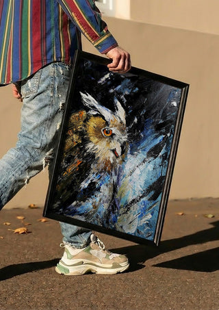Silent wisdom by Lüba carried in a black frame along a sunny street