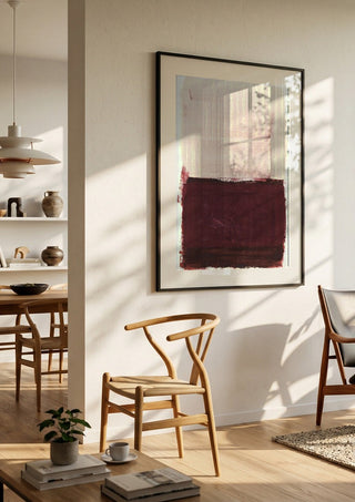 colorfields pale pink warm red by Iris Lehnhardt in a black frame in a bright dining room with wooden chairs