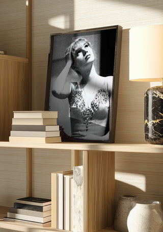 The Russian ballet dancer by Bettinafloorphoto in a dark frame on a wooden shelf beside books and a lamp