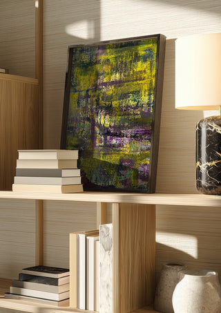 Sonnenschein by Sophie Schillen in a dark frame on a wooden shelf beside books and a lamp