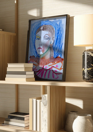 Who's the Clown now by DNF in a dark frame on a wooden shelf beside books and a lamp